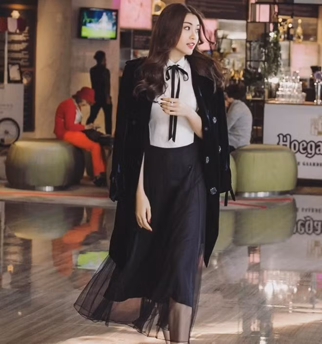 Á hậu Lệ Hằng diện sơ mi trắng và chân váy xuyên thấu mang dấu ấn phong cách preppy. Tuy vậy, chiếc áo khoác nhung bên ngoài dường như lại đem đến vẻ sang trọng, giúp kiều nữ thăng hạng trong danh sách những mỹ nhân mặc đẹp