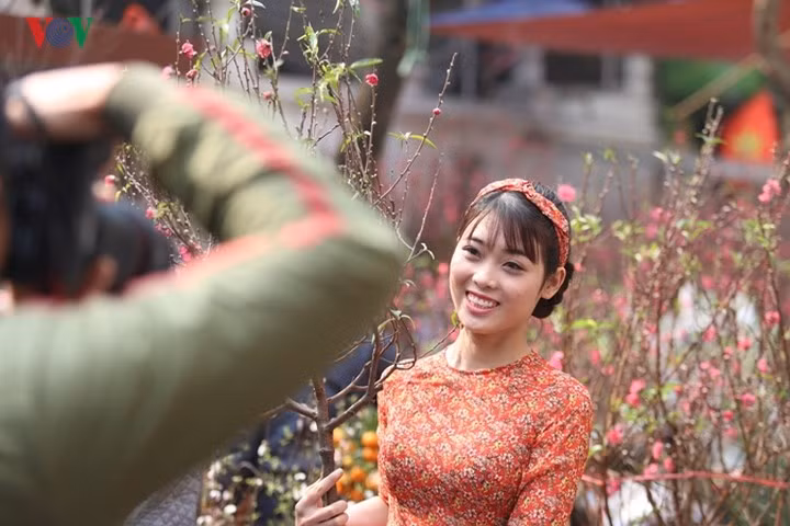  tại các chợ hoa dọc các đường Phùng Hưng, Hàng Lược, Hàng Chai hay Hàng Mã... rất nhiều người dân vận những bộ áo dài duyên dáng hòa mình cùng hương sắc hoa thắm và khung cảnh xuân đang về.