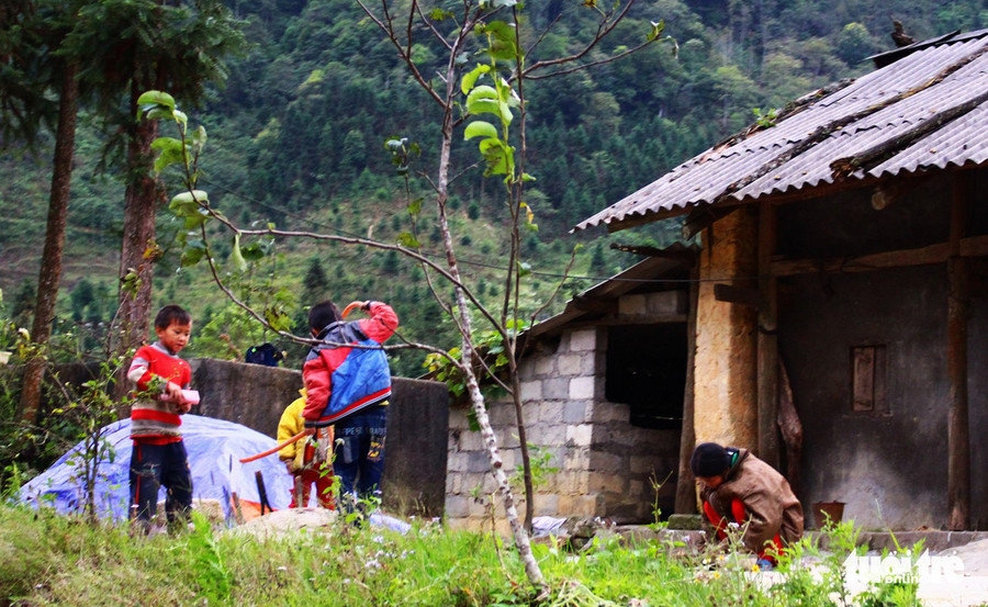 Những đứa trẻ miền cao chơi đùa bên mái hiên nhà, núi rừng bao quanh cả tuổi thơ