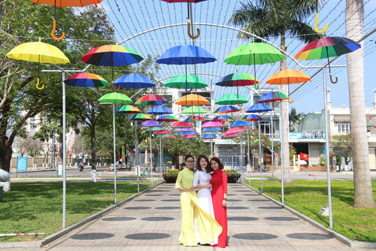  Những cô gái trẻ thướt tha với tà áo dài dưới con đường rợp bóng dù