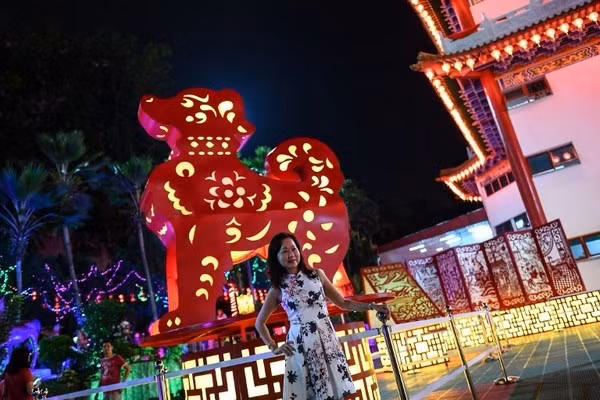  Người dân Kuala Lumpur bên cạnh đèn hình chó. Ảnh: AFP.