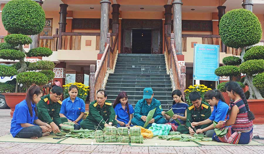Lực lượng vũ trang và thanh niên huyện Kbang gói bánh chưng tặng bà con làng kháng chiến Stơr. Ảnh: Anh Sơn
