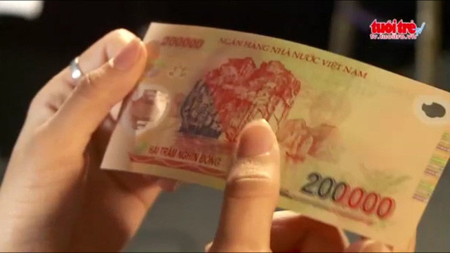Hình ảnh kiểm tra tiền giả - thật - Ảnh chụp từ clip của báo Tuổi Trẻ