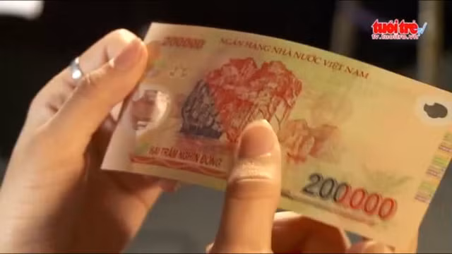 Hình ảnh kiểm tra tiền giả - thật - Ảnh chụp từ clip của báo Tuổi Trẻ