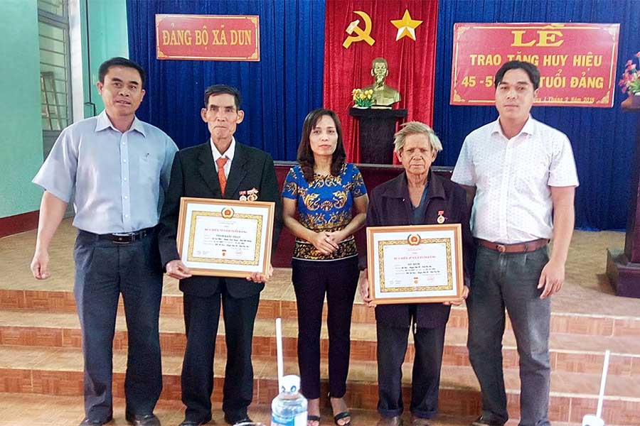  Đồng chí Rơ Mah H Bé Net và lãnh đạo Đảng ủyỷ xã Dun tại lễ trao Huy hiệu Đảng. Ảnh: Hoàng Viên