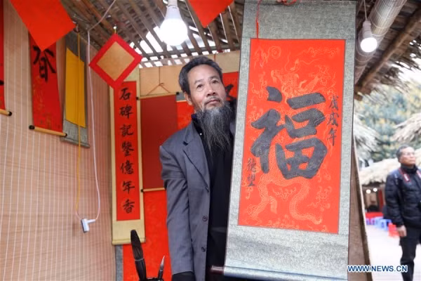  Một ông đồ viết chữ “Phúc”, có nghĩa là may mắn, trên giấy đỏ.