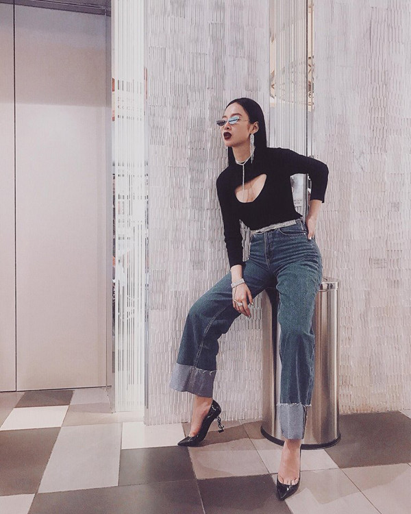 Angela Phương Trinh thể hiện sự sành điệu khi chọn các kiểu phụ kiện mắt kính, vòng cổ, hoa tai hot trend 2018 để tạo điểm nhấn cho set đồ gồm áo thun ôm, quần jean ống rộng.