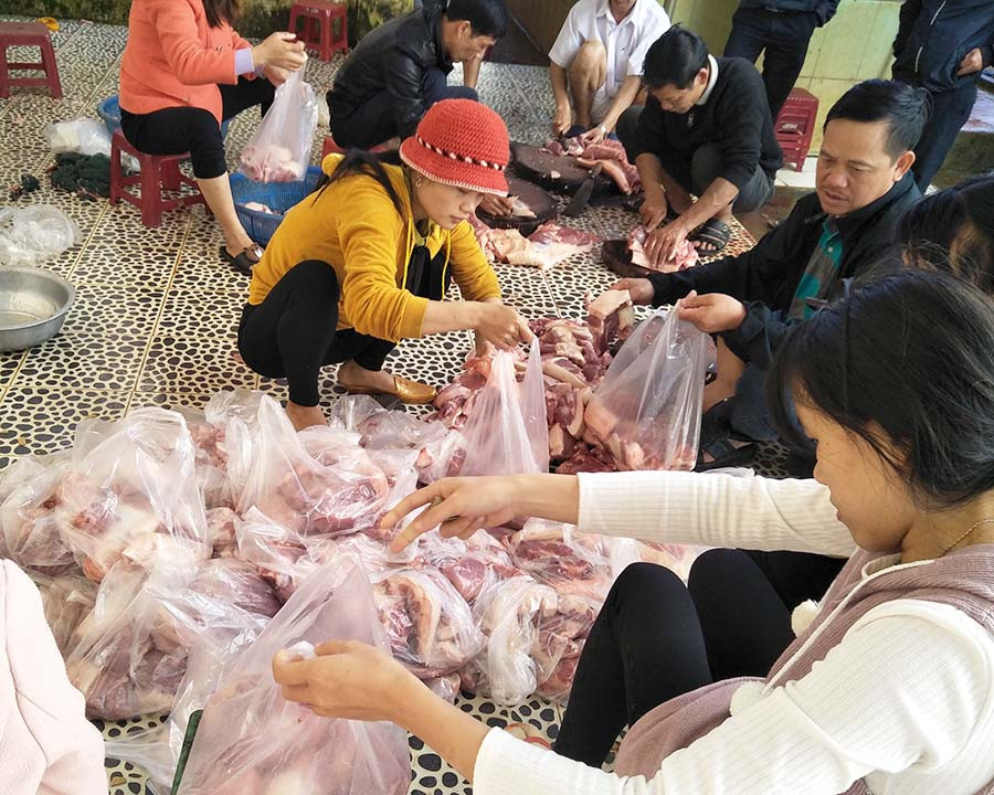  Thầy, cô giáo chia thịt heo cho các học sinh. Ảnh: N.T