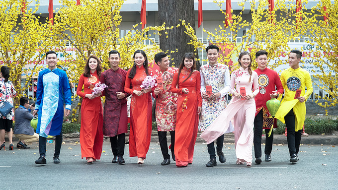 Hàng chục cây mai, đào giả được trang trí dọc tuyến đường. Không khí càng nhộn nhịp hơn khi rất nhiều bạn trẻ diện áo dài đến đây để chụp ảnh nhân dịp năm mới.