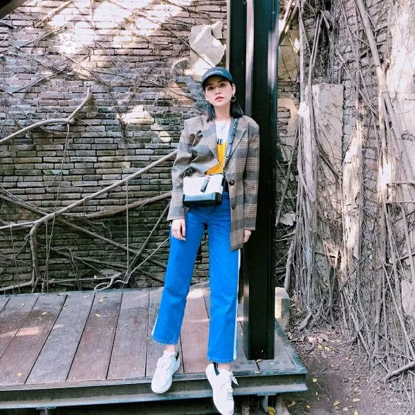 Thay vì các kiểu váy áo điệu đà, Chi Pu chọn blazer kẻ sọc, jean kẻ sọc giầy sneaker và túi Chanel Gabrielle, mũ lưỡi trai để mix đồ.