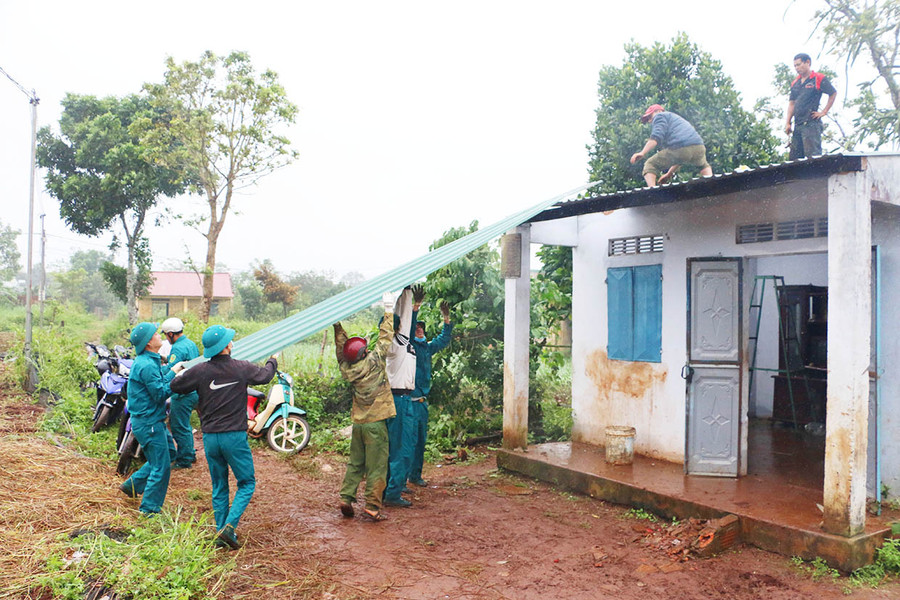 Lực lượng dân quân xã Biển Hồ (TP. Pleiku) giúp người dân lợp lại mái nhà bị tốc do bão. Ảnh: Quang Tấn 
