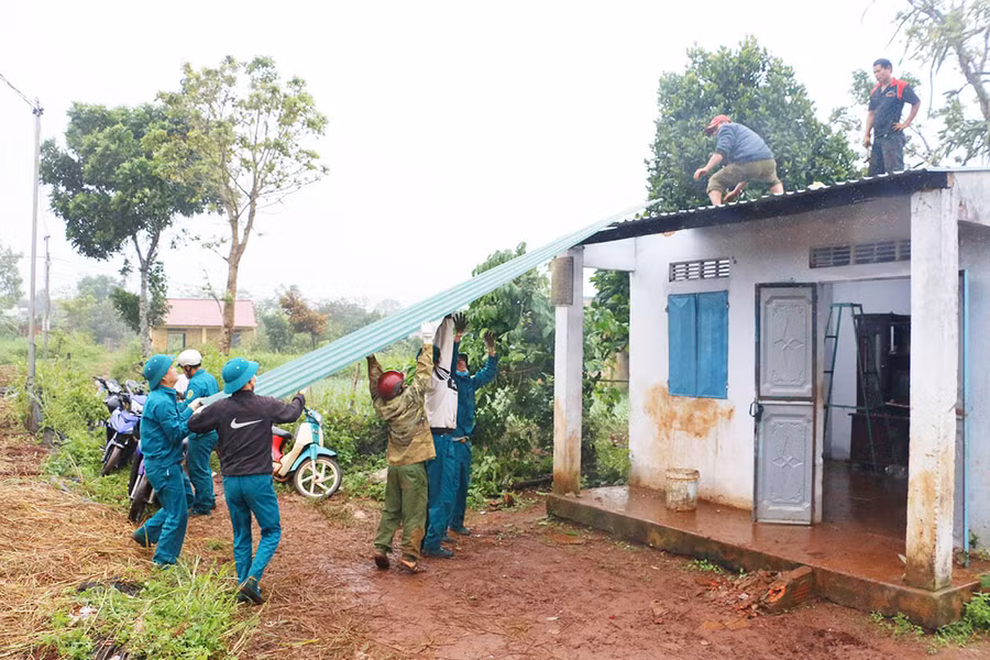 Lực lượng dân quân xã Biển Hồ (TP. Pleiku) giúp người dân lợp lại mái nhà bị tốc do bão. Ảnh: Quang Tấn 