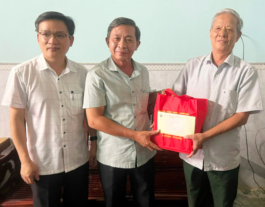  Trưởng ban Tuyên giáo Tỉnh ủy Huỳnh Thế Mạnh (đứng giữa) tặng quà ông Lê Minh Ngọc-thương binh, thị trấn Kbang. Ảnh: Đinh Yến