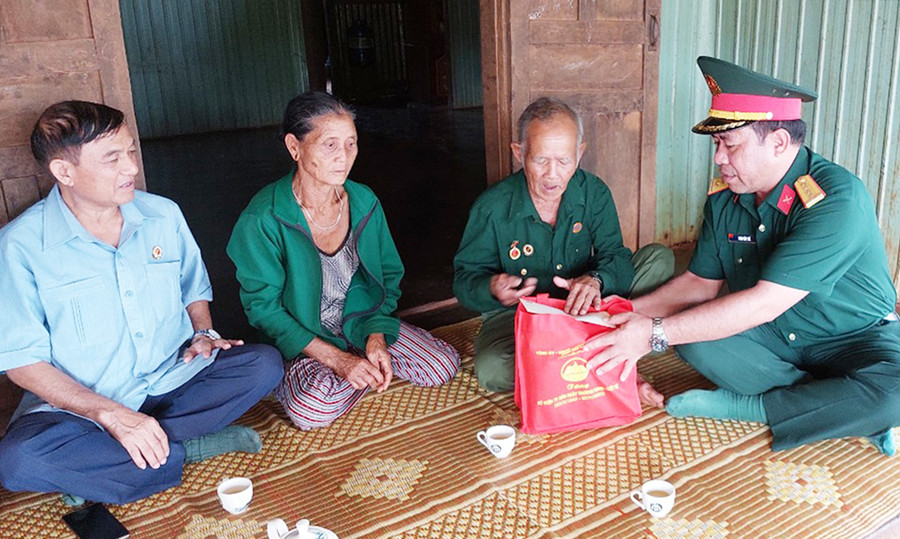 Đại tá Đinh Văn Thê gửi lời hỏi thăm sức khỏe và tặng quà cho gia đình ông Rơ Châm Bôm. Ảnh: Vĩnh Hoàng  Đồng chí Đinh Văn Thê gửi lời hỏi thăm sức khỏe và cảm ơn gia đình ông Rơ Châm Bôm. Ảnh: Vĩnh Hoàng