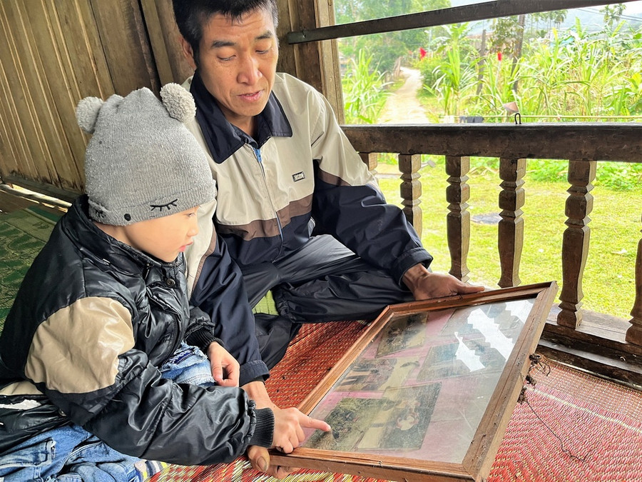 Cựu chiến binh Hoàng Văn Phát, nguyên chiến sĩ ĐBP Săm Pun kể lại chuyện bảo vệ chủ quyền với cháu nội. Ảnh: Mai Thanh Hải