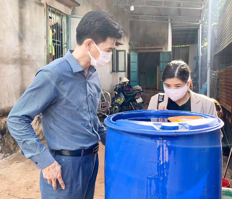  Tiến sĩ Bùi Khánh Toàn (bìa trái)-Phó Viện trưởng Viện Vệ sinh dịch tễ Tây Nguyên kiểm tra bể chứa nước tại một hộ gia đình ở xã Ia Krai (huyện Ia Grai). Ảnh: Như Nguyện