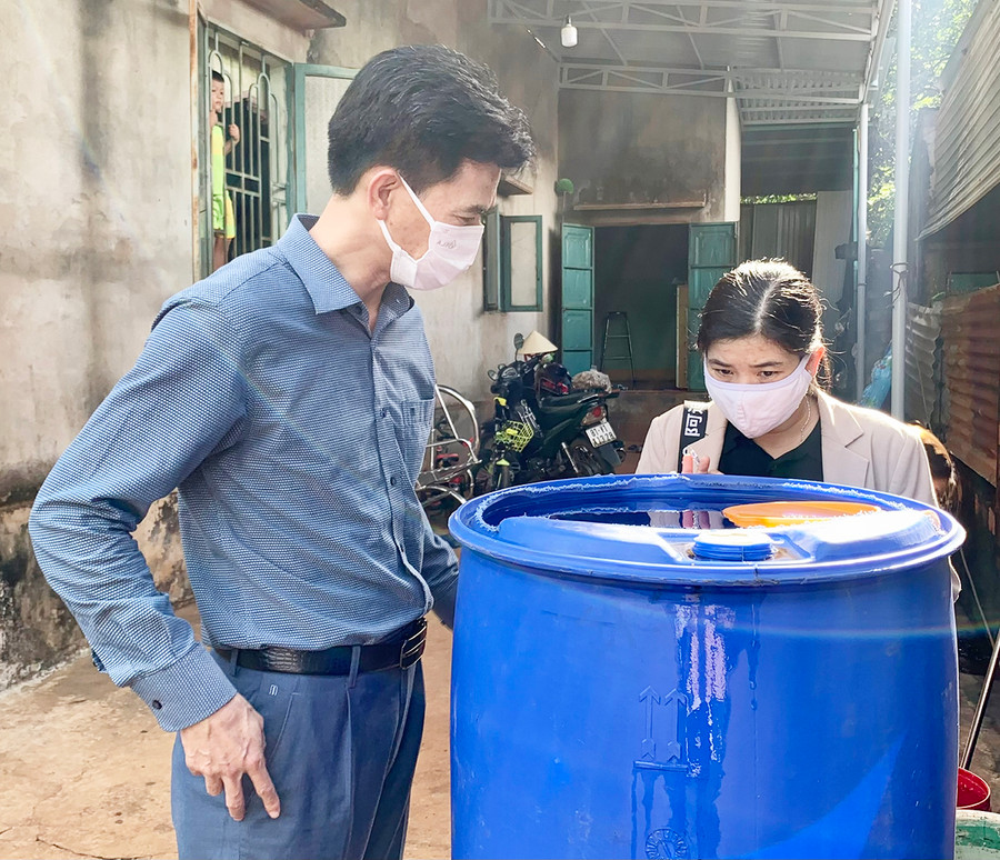  Tiến sĩ Bùi Khánh Toàn (bìa trái)-Phó Viện trưởng Viện Vệ sinh dịch tễ Tây Nguyên kiểm tra bể chứa nước tại một hộ gia đình ở xã Ia Krai (huyện Ia Grai). Ảnh: Như Nguyện