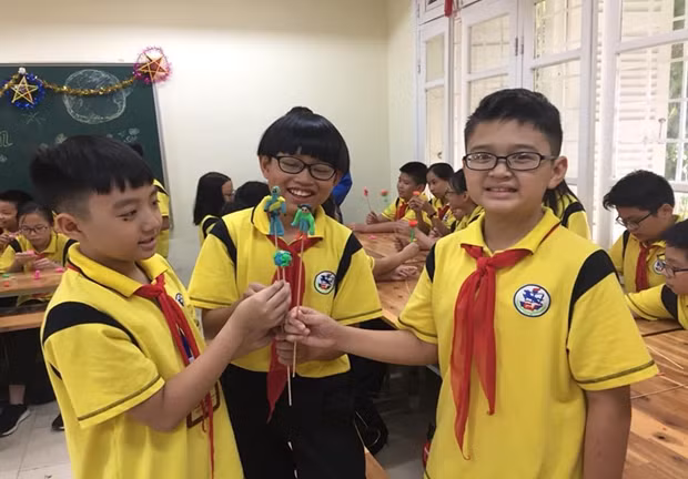 Gia Khánh (ở giữa) đang vui sướng khoe sản phẩm nặn tò he của mình với các bạn trong chương trình “Vui Trung thu” với các bạn A21. (Ảnh: NTCC)