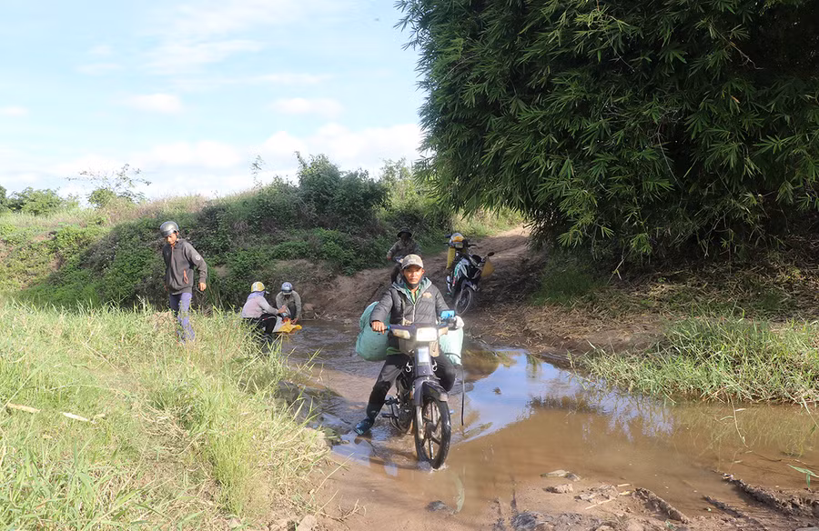  Anh Đinh Văn Nhâm (tổ dân phố Plei Dơng, thị trấn Kông Chro) khó nhọc chở bao đậu xanh vượt qua lòng suối Srơh. Ảnh: N.M