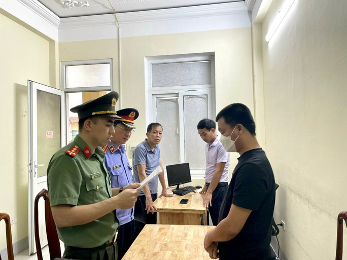 Cơ quan công an đọc lệnh khởi tố đối với Phạm Văn Bằng (áo đen) - Ảnh: Công an Hà Tĩnh