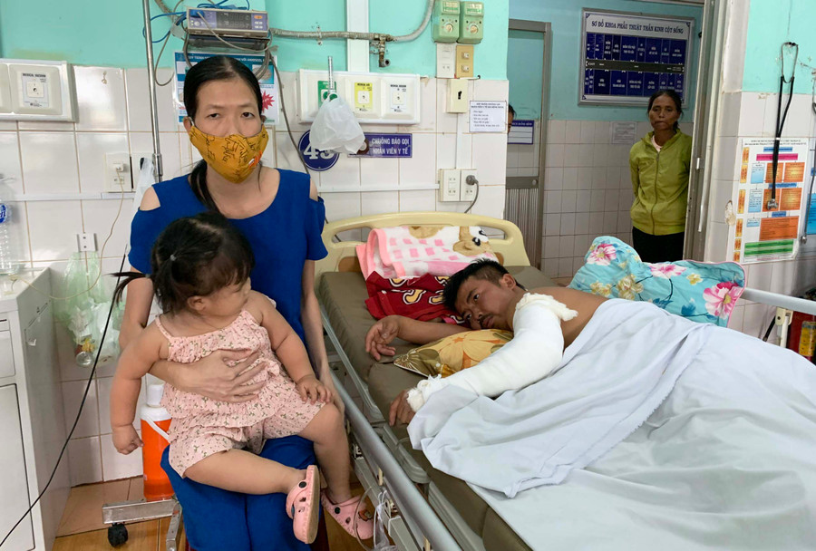 Chị Hồ Thị Thanh Vân vừa chăm sóc con nhỏ, vừa chăm chồng khi anh Phạm Ngọc Tuân còn điều trị tại Bệnh viện Đa khoa tỉnh. Ảnh: Như Ý