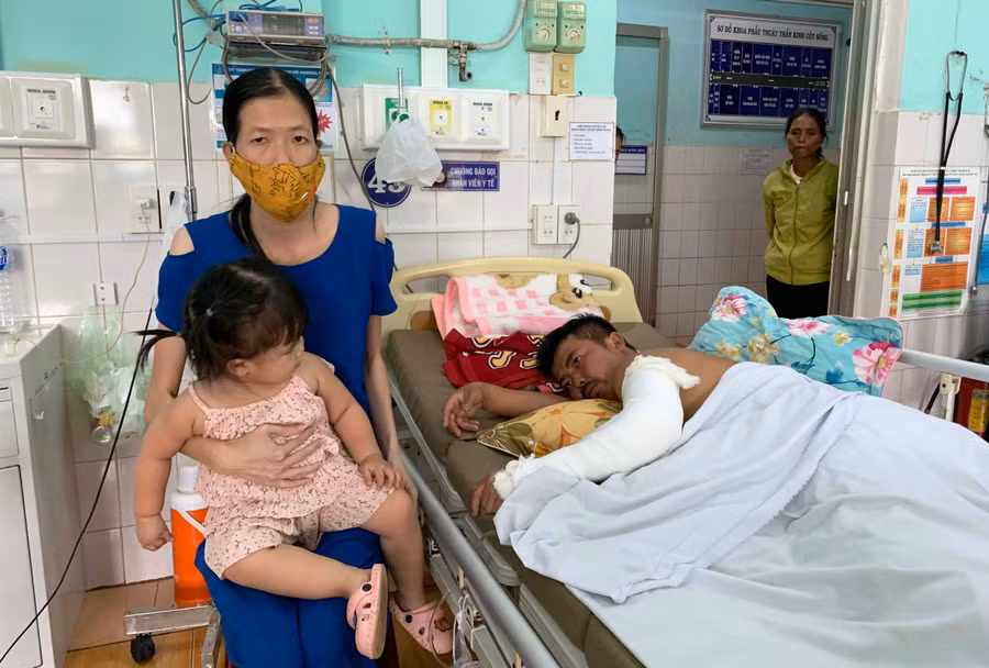 Chị Hồ Thị Thanh Vân vừa chăm sóc con nhỏ, vừa chăm chồng khi anh Phạm Ngọc Tuân còn điều trị tại Bệnh viện Đa khoa tỉnh. Ảnh: Như Ý