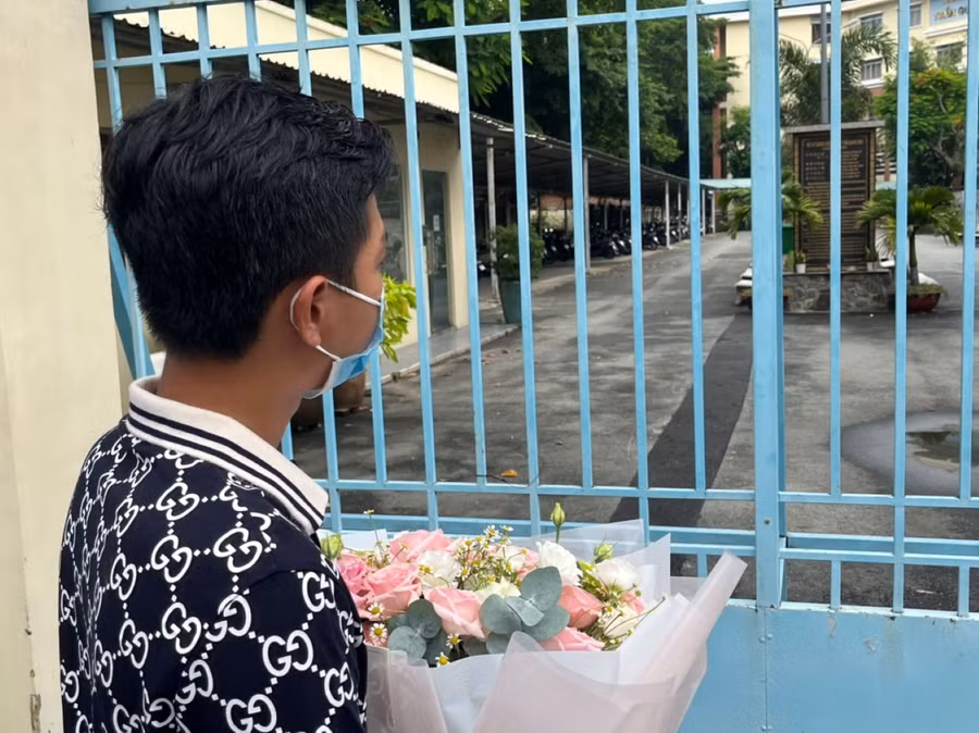 M.K cầm đóa hoa hướng về phòng thi. Ảnh: Kim Ngọc Nghiên