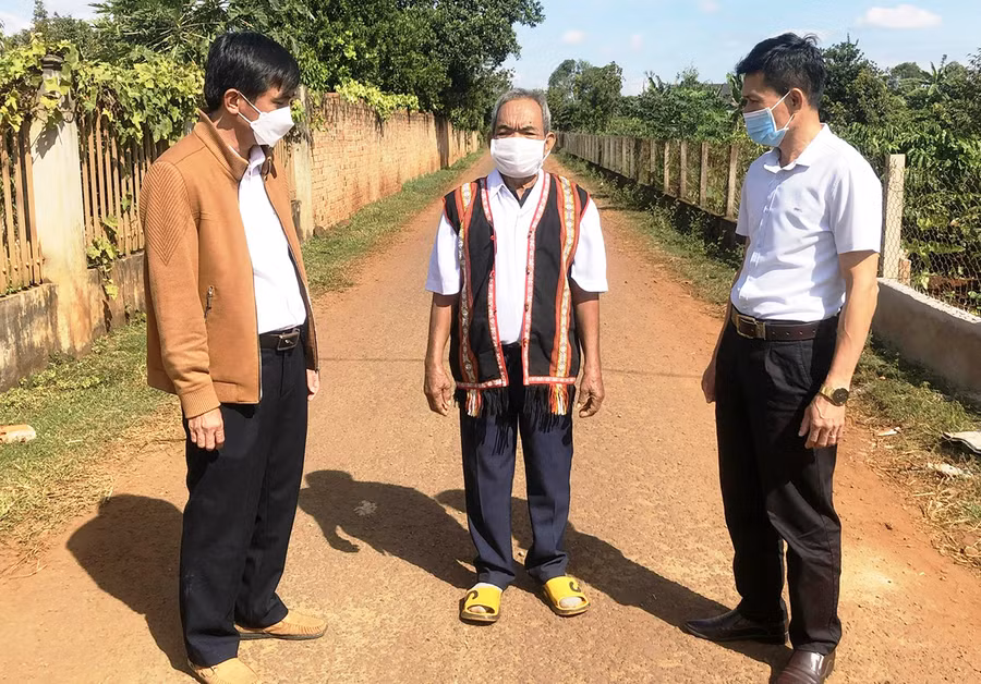 Ông Rơ Châm Kóp (giữa) trao đổi với cán bộ trẻ của huyện về những vấn đề phát triển kinh tế- xã hội ở địa phương. Ảnh: Đinh Yến