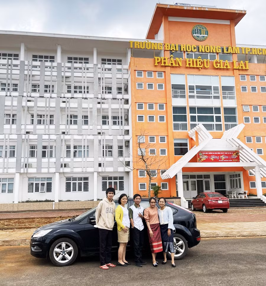 4 sinh viên Lào chụp ảnh cùng giảng viên (thứ 2 từ trái sang) trong khuôn viên Phân hiệu Trường Đại học Nông Lâm TP. Hồ Chí Minh tại Gia Lai. Ảnh: Phương Dung