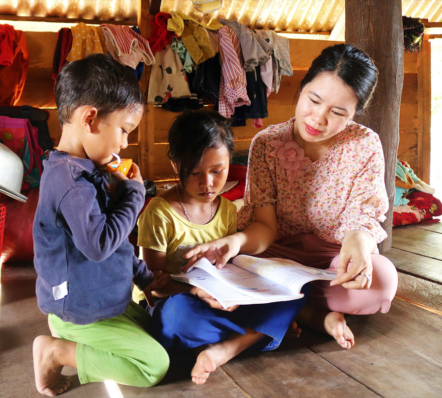 Chị Ngô Thị Huyền-Chủ tịch Hội LHPN xã Chư Gu (huyện Krông Pa)hướng dẫn 2 chị em Siu Kasi học bài. Ảnh: Hoành Sơn