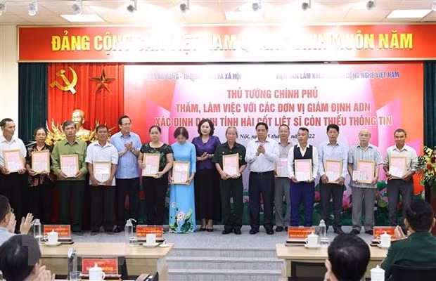  Thủ tướng Phạm Minh Chính trao kết quả giám định ADN cho gia đình liệt sỹ. (Ảnh: Dương Giang/TTXVN)