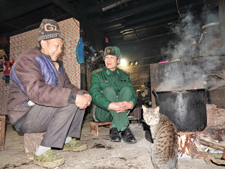 Anh Chào Chỉn Xiền (trái) kể chuyện chống lấn chiếm với chỉ huy đồn BP Xín Cái. Ảnh: Mai Thanh Hải