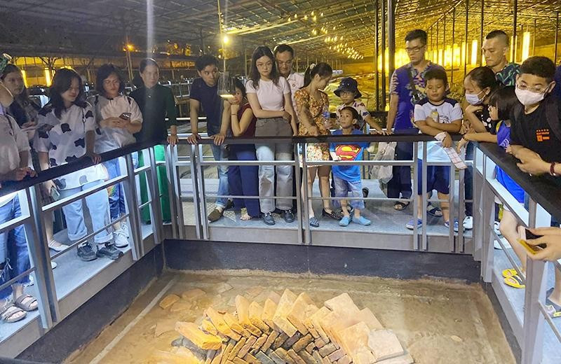 Khách du lịch tham quan giếng cổ trong Hoàng thành Thăng Long (Hà Nội). Ảnh: Chí Dũng