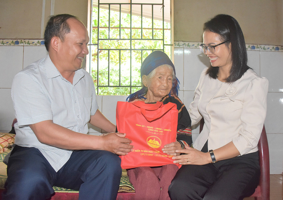 Phó Bí thư Tỉnh ủy Rah Lan Chung tặng quà Bà mẹ Việt Nam anh hùng Rmah Amĩa (làng O Grưng, xã Ia Kol). Ảnh: Trần Dung