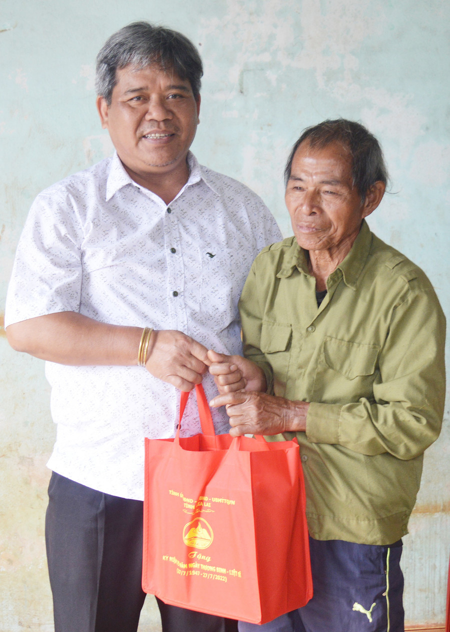 Chủ tịch Ủy ban MTTQ Việt Nam tỉnh tặng quà ông Jêt-người hoạt động kháng chiến. Ảnh: Anh Huy