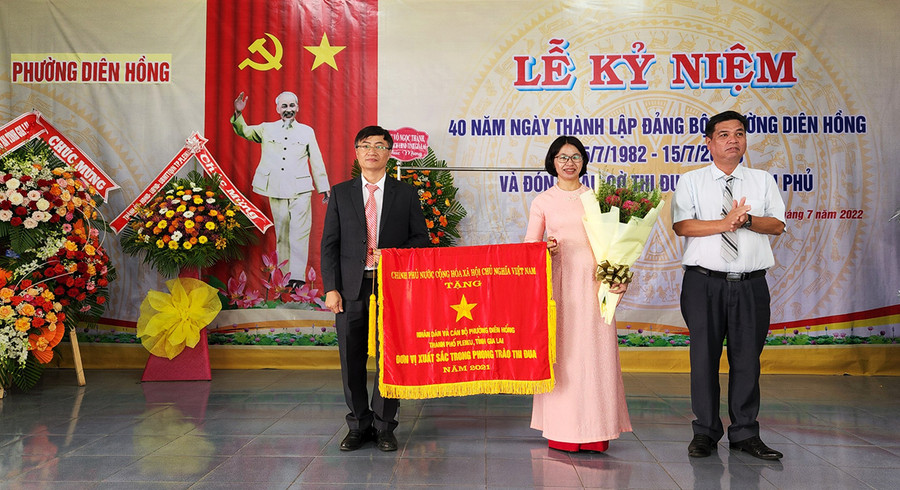 Thừa ủy quyền của Thủ tướng Chính phủ, đồng chí Kpă Thuyên (bìa phải)-Phó Chủ tịch UBND tỉnh tặng cờ thi đua cho nhân dân và cán bộ phường Diên Hồng. Ảnh: Phan Lài