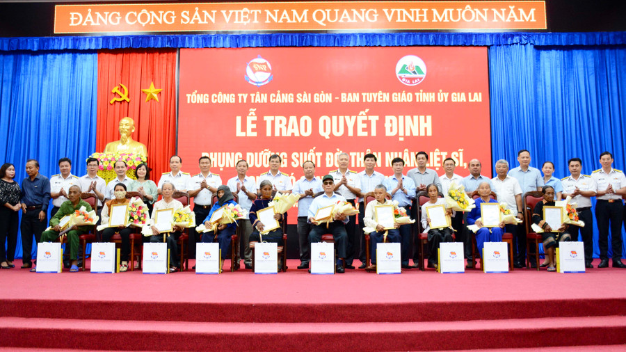 10 thân nhân liệt sĩ, người có công với cách mạng trên địa bàn tỉnh nhận quyết định phụng dưỡng, tiền phụng dưỡng, hoa, quà của Tổng Công ty Tân Cảng Sài Gòn tại buổi lễ. Ảnh: Lam Nguyên