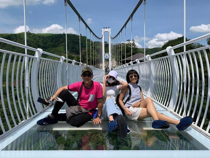 Du khách nước ngoài chụp ảnh trên cầu kính Bạch Long (Ảnh: HaNoiToursExpert)