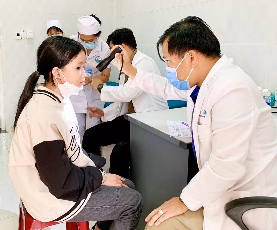  Các bác sĩ Hội Phẫu thuật nhi Việt Nam khám sàng lọc cho một bệnh nhi khuyết tật tại tỉnh. Ảnh: Như Nguyện