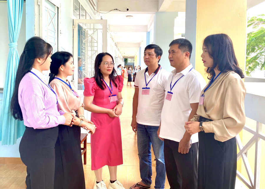 Các cán bộ chấm thi tự luận trao đổi nghiệp vụ trước giờ làm nhiệm vụ. Ảnh: Mộc Trà