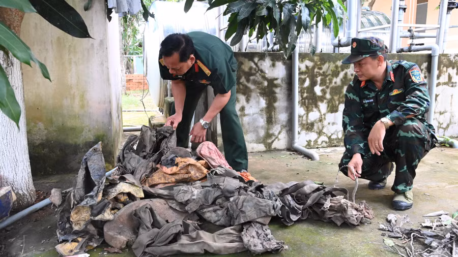 Dù phi công và một số vật dụng được tìm thấy tại khu vực ao nuôi tôm của ông Chăm. Ảnh: Nam Long 