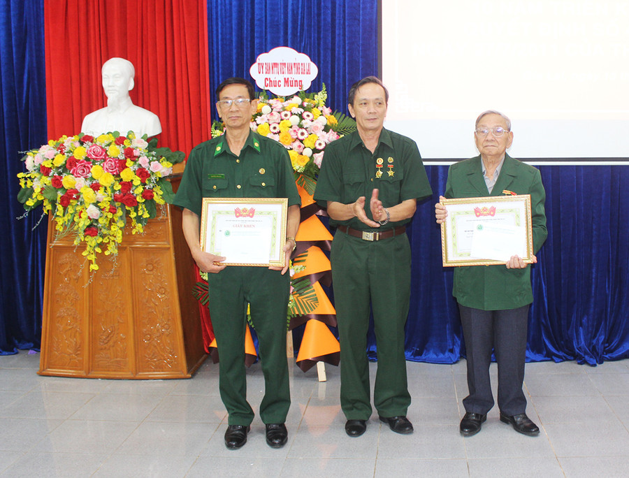 Ông Trần Văn Bình (ở giữa)-Chủ tịch Hội cựu TNXP tỉnh tặng giấy khen cho 2 tập thể có thành tích xuất sắc trong thực hiện Quyết định số 40 của Thủ tướng Chính phủ. Ảnh: Phan Lài