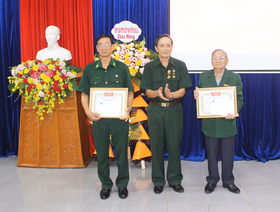 Ông Trần Văn Bình (ở giữa)-Chủ tịch Hội cựu TNXP tỉnh tặng giấy khen cho 2 tập thể có thành tích xuất sắc trong thực hiện Quyết định số 40 của Thủ tướng Chính phủ. Ảnh: Phan Lài