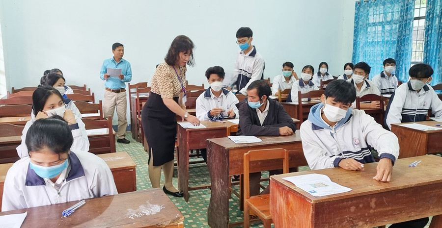 Cán bộ coi thi kiểm tra giấy báo thi của thí sinh tại điểm thi Trường THPT Trần Hưng Đạo. Ảnh: Hà Phương