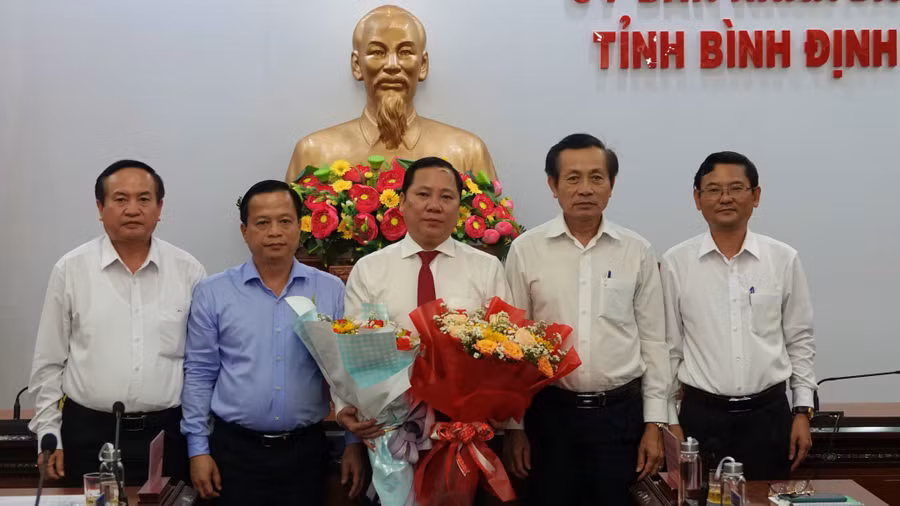Lãnh đạo Tỉnh ủy, HĐND, UBND tỉnh Bình Định tặng hoa chúc mừng ông Nguyễn Phi Long (ở giữa) được Bộ Chính trị chỉ định giữ chức Bí thư Tỉnh ủy Hòa Bình. Ảnh: Hoàng Trọng