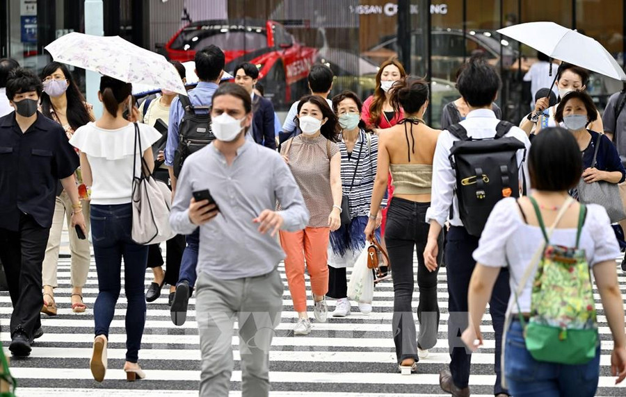 Người dân đeo khẩu trang phòng dịch Covid-19 khi di chuyển tại Tokyo, Nhật Bản ngày 21-7-2022. Ảnh: Kyodo/TTXVN