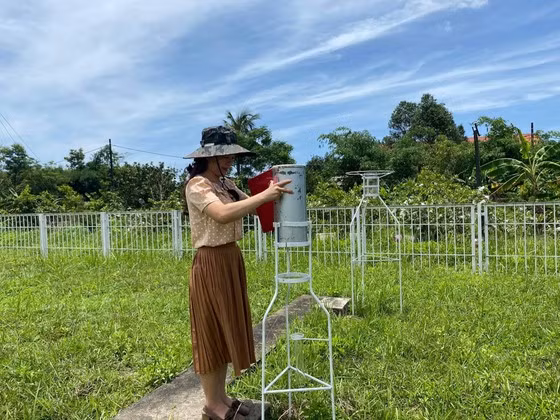 Quan trắc viên thu thập lượng mưa ở trạm khí tượng - thủy văn. Ảnh: HOÀI LINH