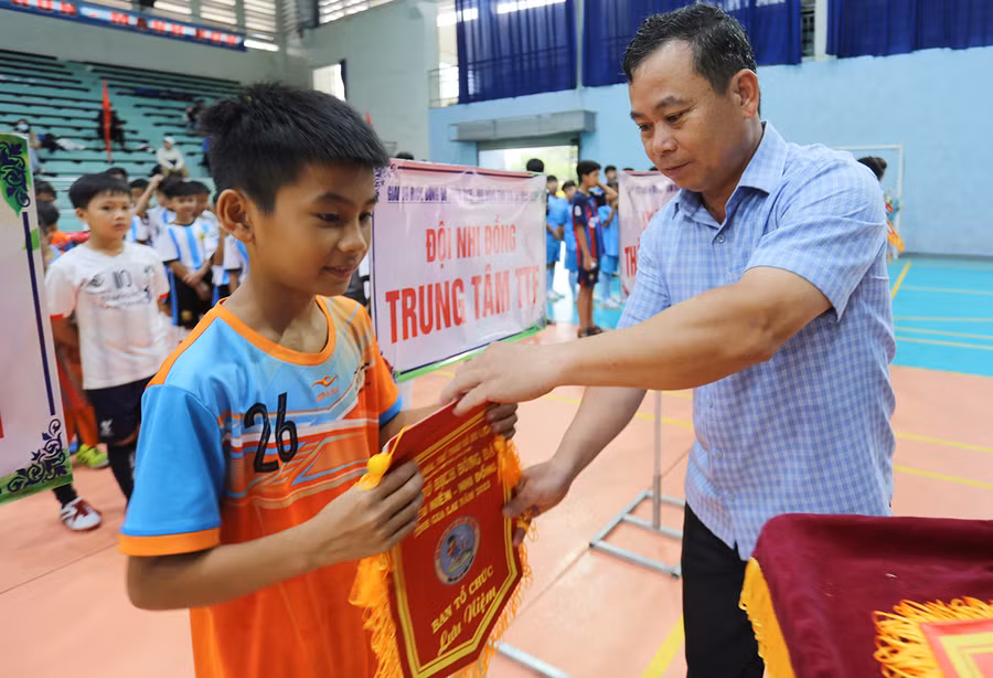  Ông Nguyễn Văn Ý-Phó Giám đốc Sở Văn hóa-Thể thao và Du lịch tỉnh tặng cờ lưu niệm cho đại diện các đội bóng tham gia giải. Ảnh: Văn Ngọc
