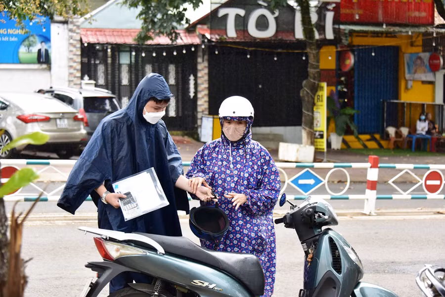 Thí sinh đội mưa đến điểm thi vào chiều 7-7. Ảnh: Đức Thụy