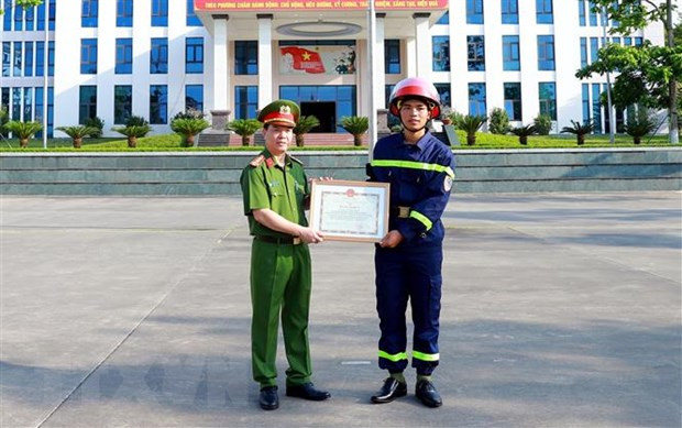 Đại tá Đỗ Tiến Thùy, Phó Giám đốc Công an tỉnh Tuyên Quang, trao Bằng khen của Chủ tịch UBND tỉnh cho chiến sỹ Quan Ngọc Hoàng. (Ảnh: Quang Cường/TTXVN)